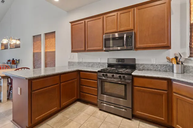 a kitchen with stainless steel appliances granite countertop a stove microwave and sink