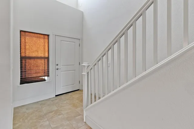 a view of staircase with railing and white walls
