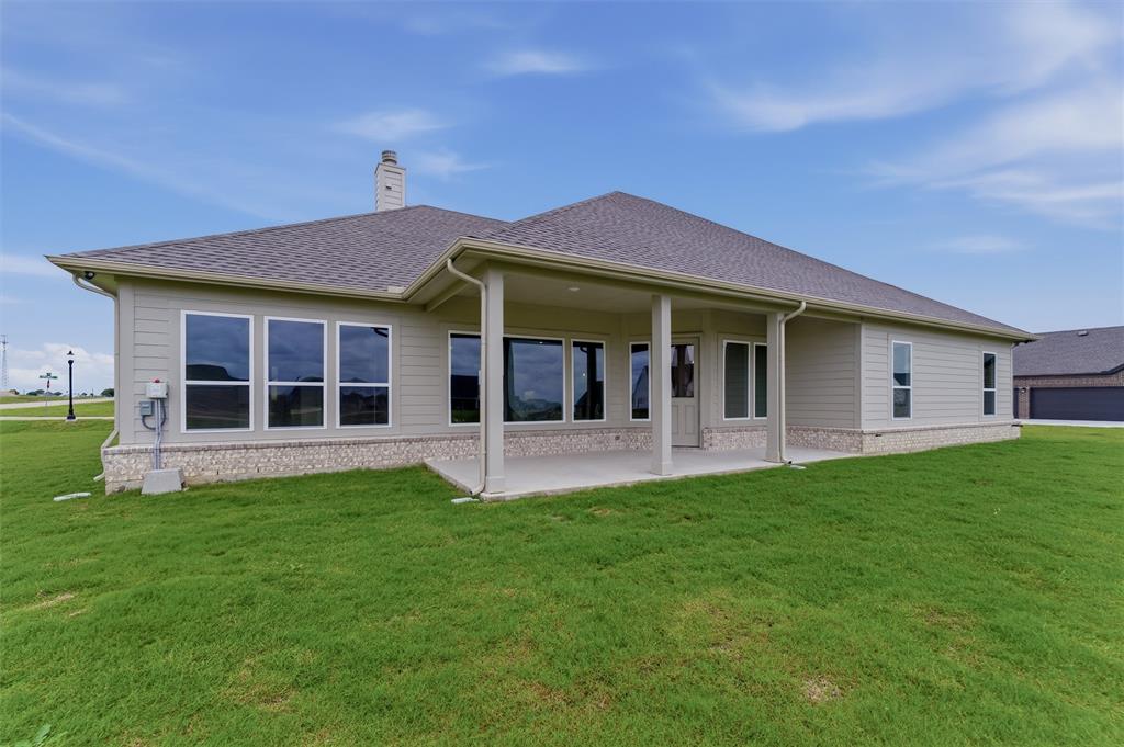 2204 Continent Court Krum, TX 76249 - Photo 26 of 28 Rear elevation featuring a covered patio with columns, multiple large windows, and a chimney