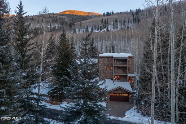 a front view of a house with a yard and tree s