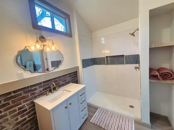 a bathroom with a sink a mirror and a shower