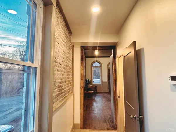 a view of a hallway with wooden floor and windows