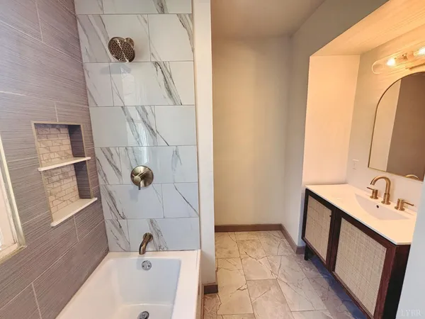 a bathroom with a tub sink and mirror