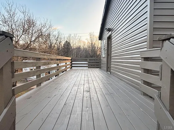 a view of balcony with wooden floor and fence and a barbeque grill