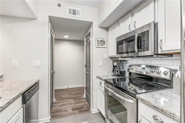 a kitchen with stainless steel appliances granite countertop a stove and a microwave