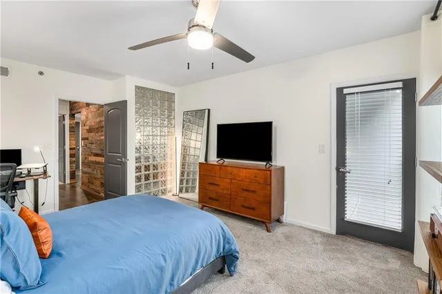 a bedroom with a bed and a flat tv screen on dresser