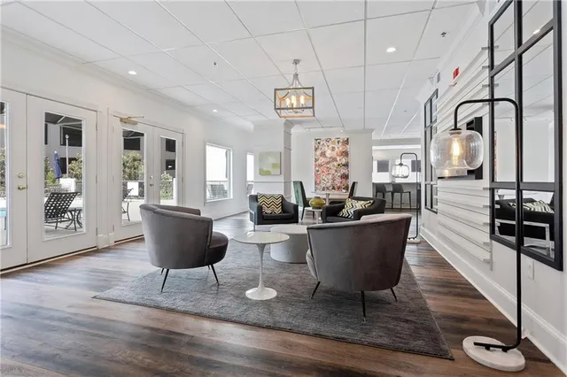 a living room with couches and kitchen view with wooden floor