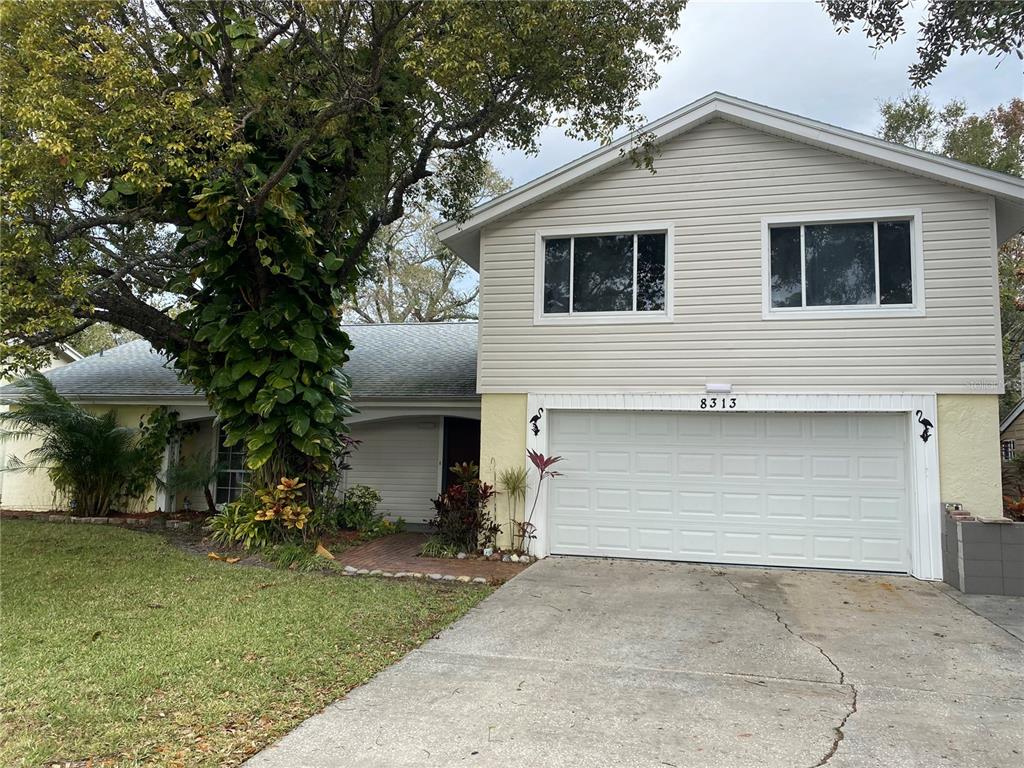 a view of house with outdoor space and parking