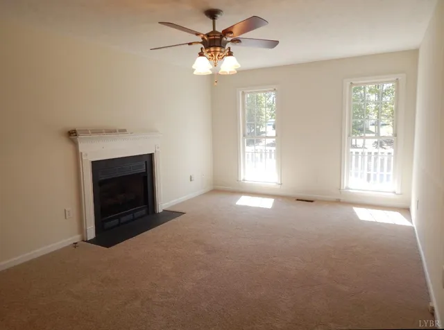 an empty room with windows and fireplace
