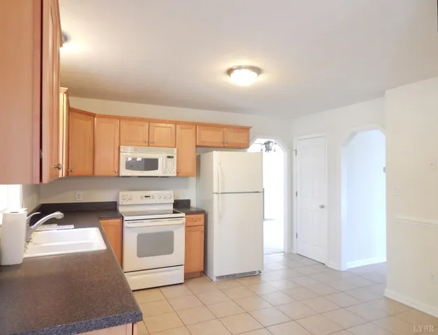 a kitchen with a refrigerator a stove top oven and cabinets