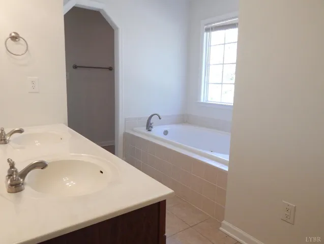 a bathroom with a tub sink and mirror