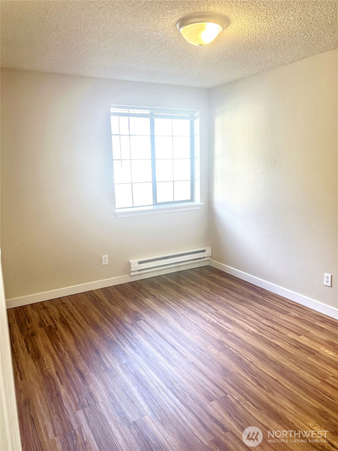 10018 Golden Given Road East, Unit 33 Tacoma, WA 98445 - Photo 4 of 8 an empty room with wooden floor and windows