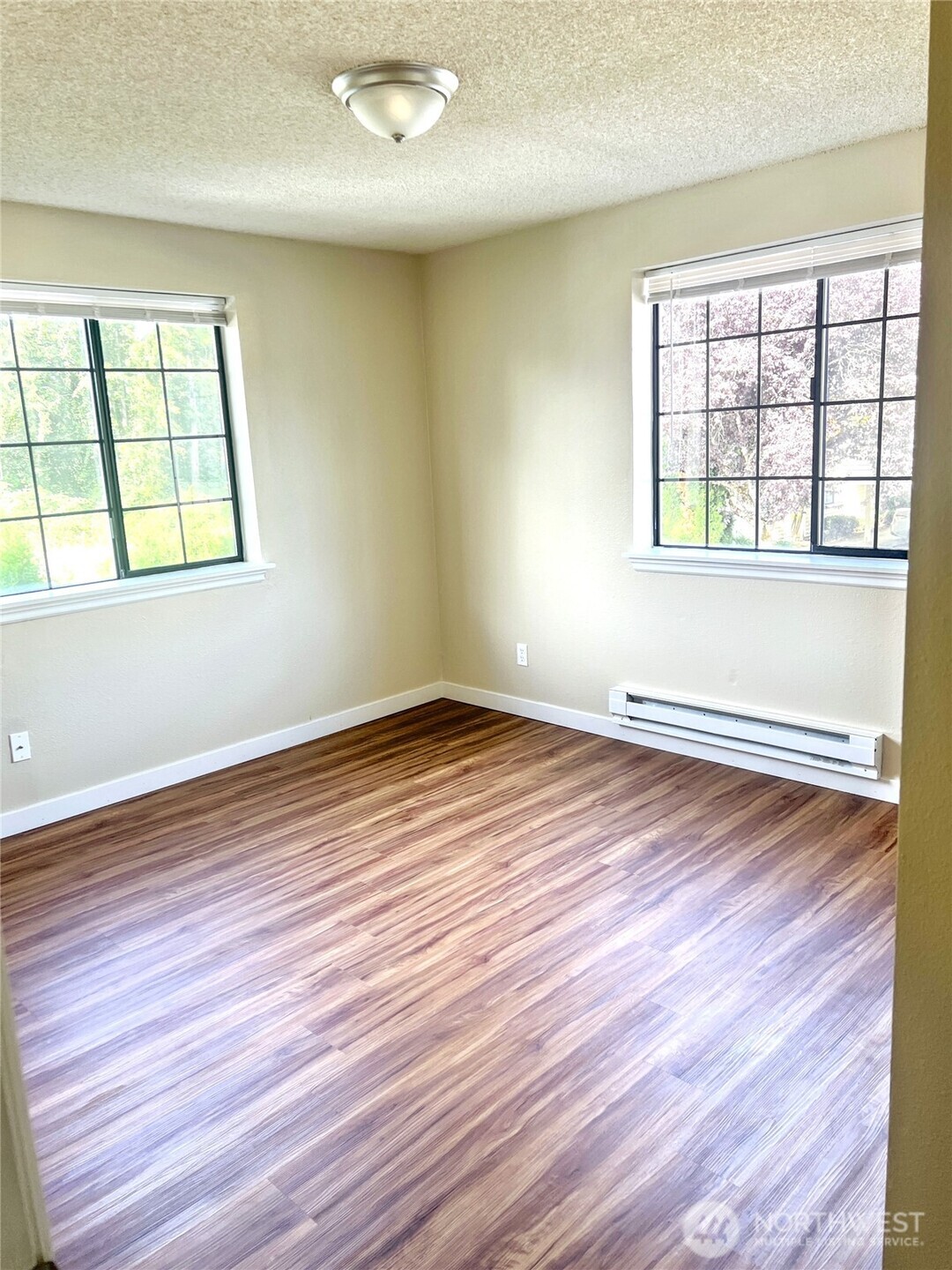 10018 Golden Given Road East, Unit 33 Tacoma, WA 98445 - Photo 5 of 8 an empty room with wooden floor and windows