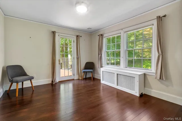 a living room with wooden floors and a large window