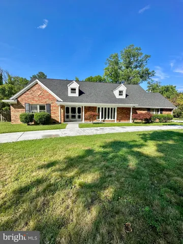 a front view of a residential houses with yard and green space