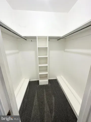 an empty room with windows and ceiling fan