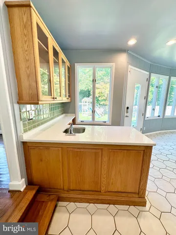 a kitchen with stainless steel appliances a sink a stove a refrigerator cabinets and a dining table