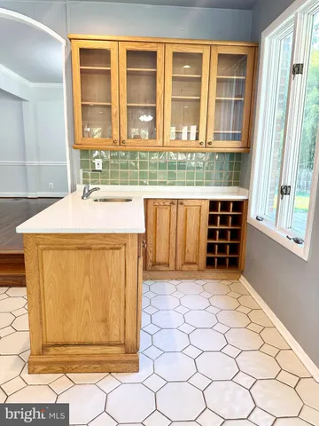 a kitchen with stainless steel appliances kitchen island granite countertop a sink a stove white cabinets a dining table and chairs