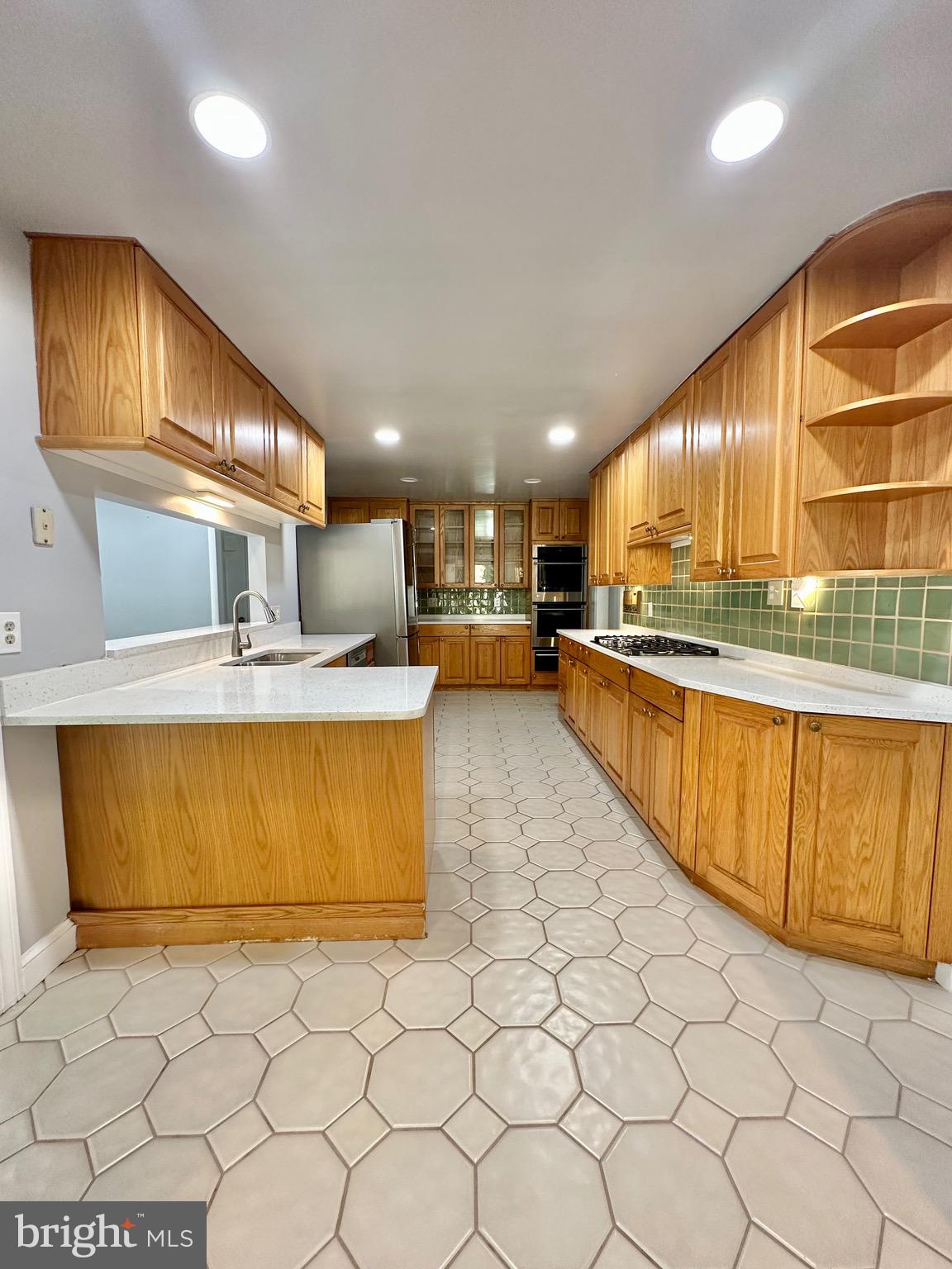 12312 Loch Carron Circle Fort Washington, MD 20744 - Photo 27 of 57 a kitchen with stainless steel appliances a sink a stove a refrigerator cabinets and a dining table