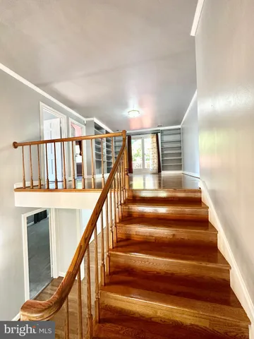 a view of an empty room with glass door and wooden floor