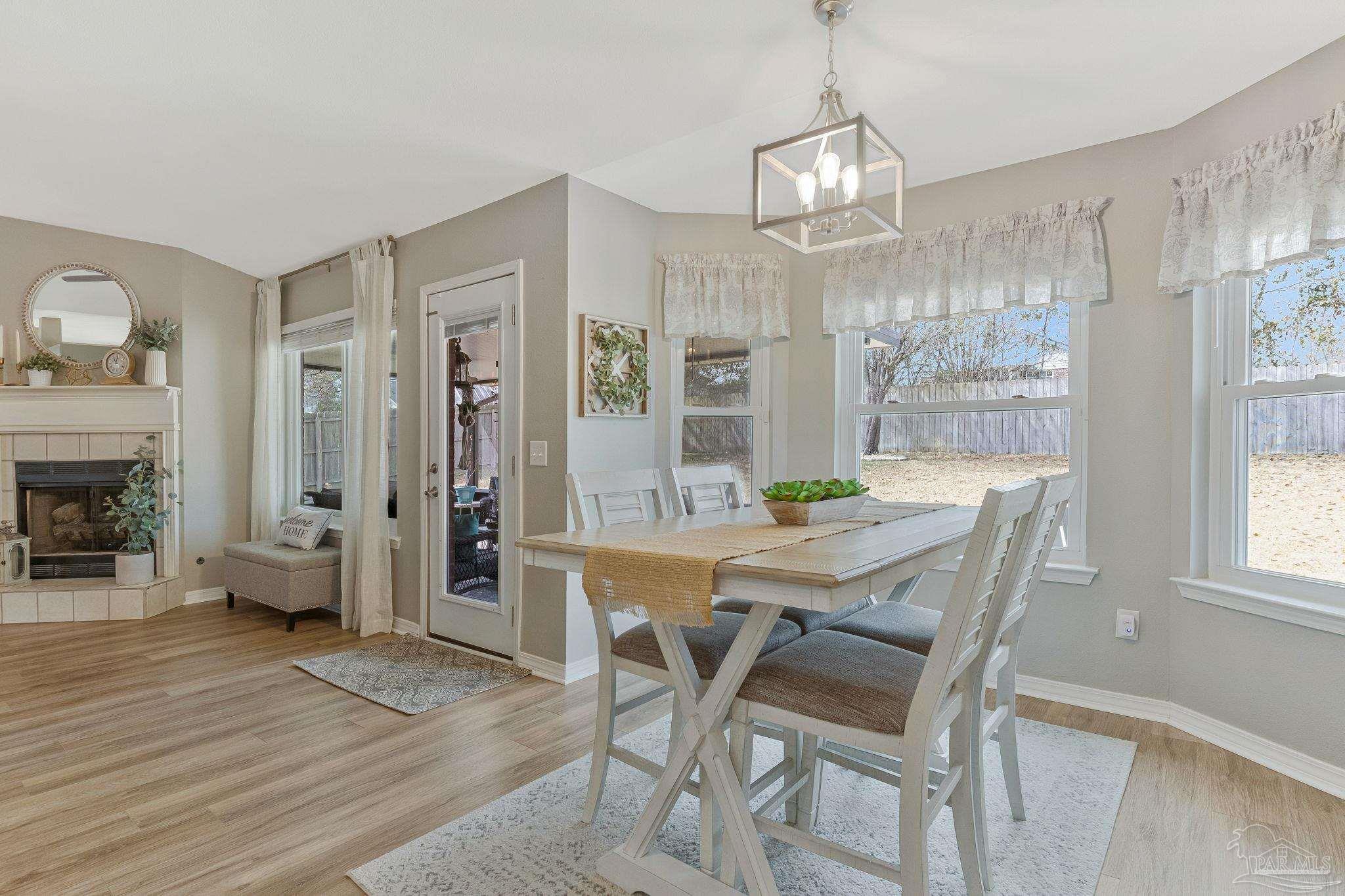 2407 Pine Forest Road Cantonment, FL 32533 - Photo 12 of 60 a view of a dining room with furniture window and wooden floor