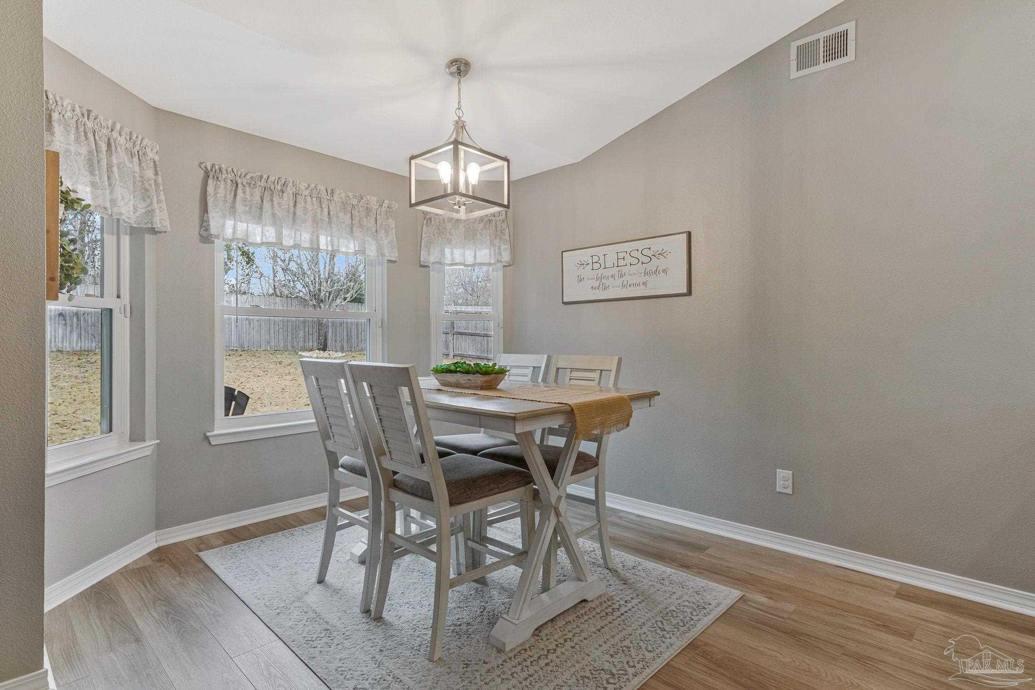2407 Pine Forest Road Cantonment, FL 32533 - Photo 15 of 60 a view of a dining room with furniture a chandelier and wooden floor