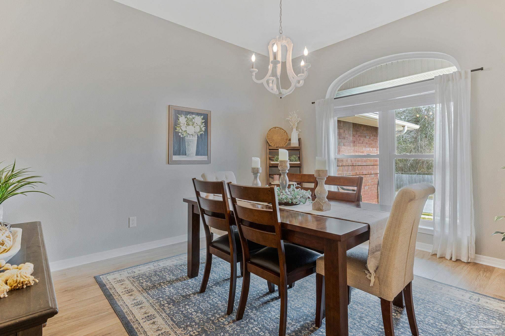 2407 Pine Forest Road Cantonment, FL 32533 - Photo 16 of 60 a view of a dining room with furniture window and wooden floor