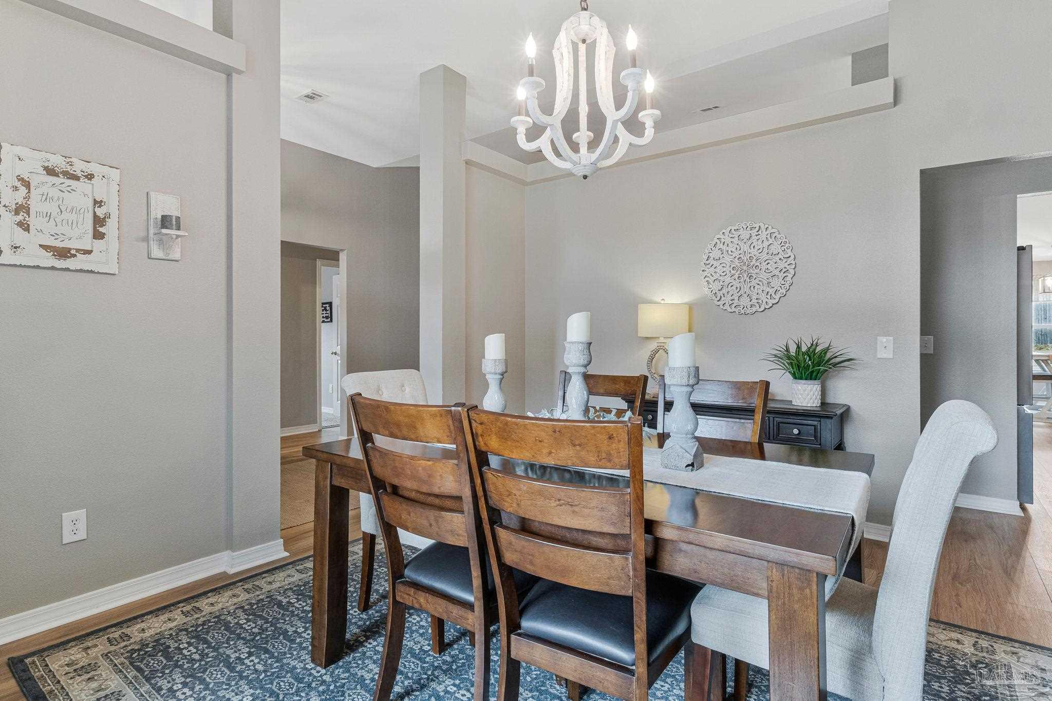 2407 Pine Forest Road Cantonment, FL 32533 - Photo 18 of 60 a dining room with furniture a chandelier and wooden floor