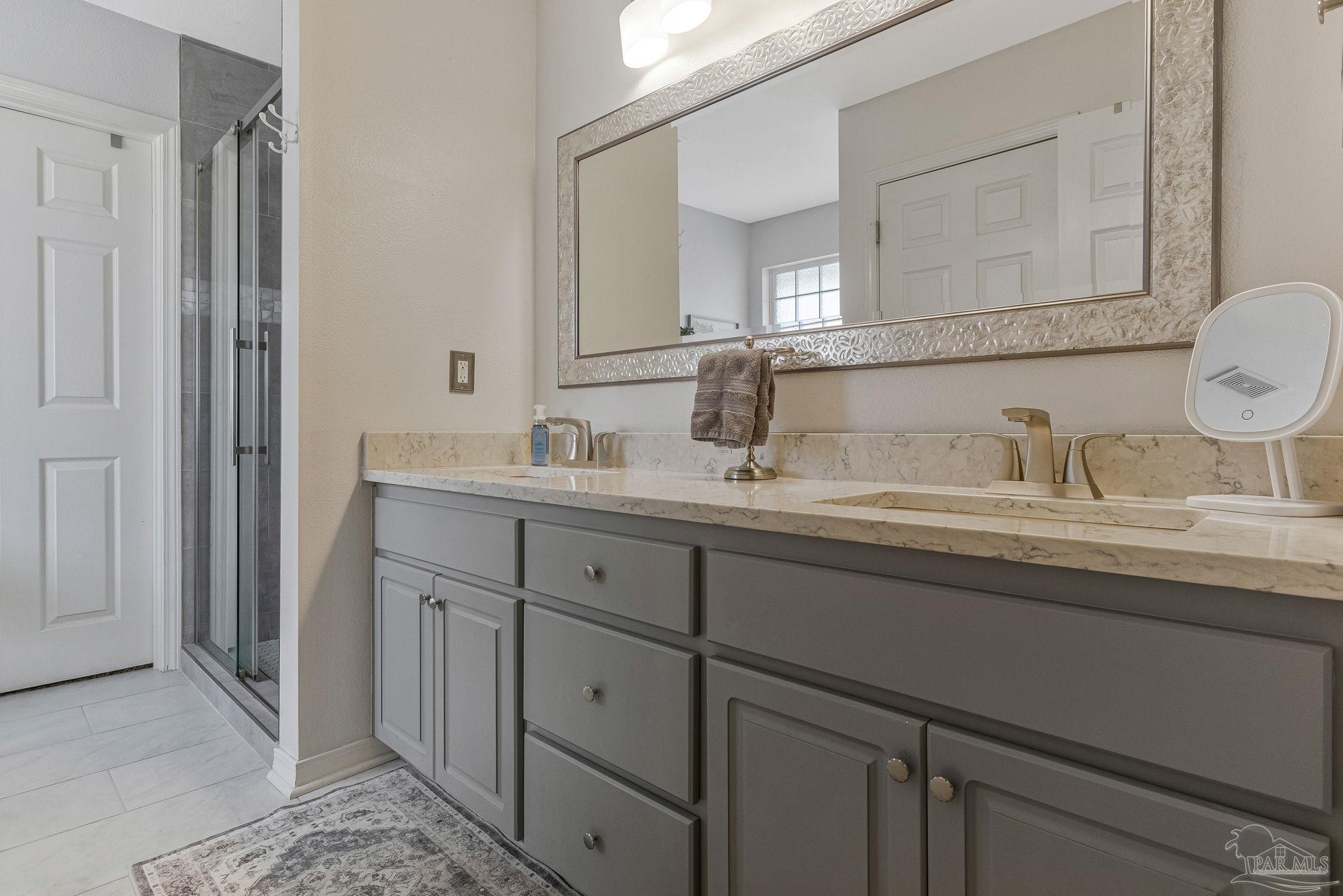 2407 Pine Forest Road Cantonment, FL 32533 - Photo 23 of 60 a bathroom with a double vanity sink and a mirror
