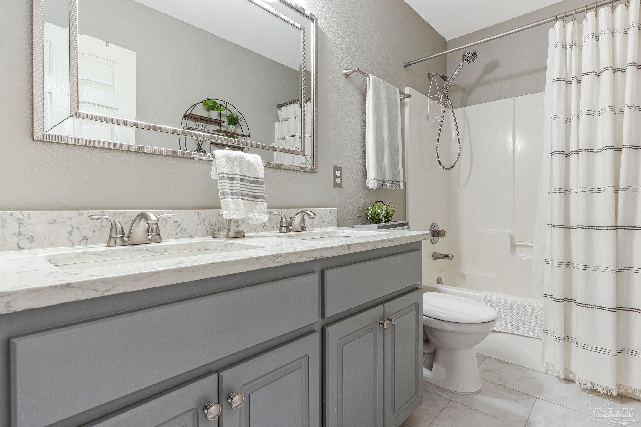 2407 Pine Forest Road Cantonment, FL 32533 - Photo 32 of 60 a bathroom with a granite countertop sink toilet mirror and shower