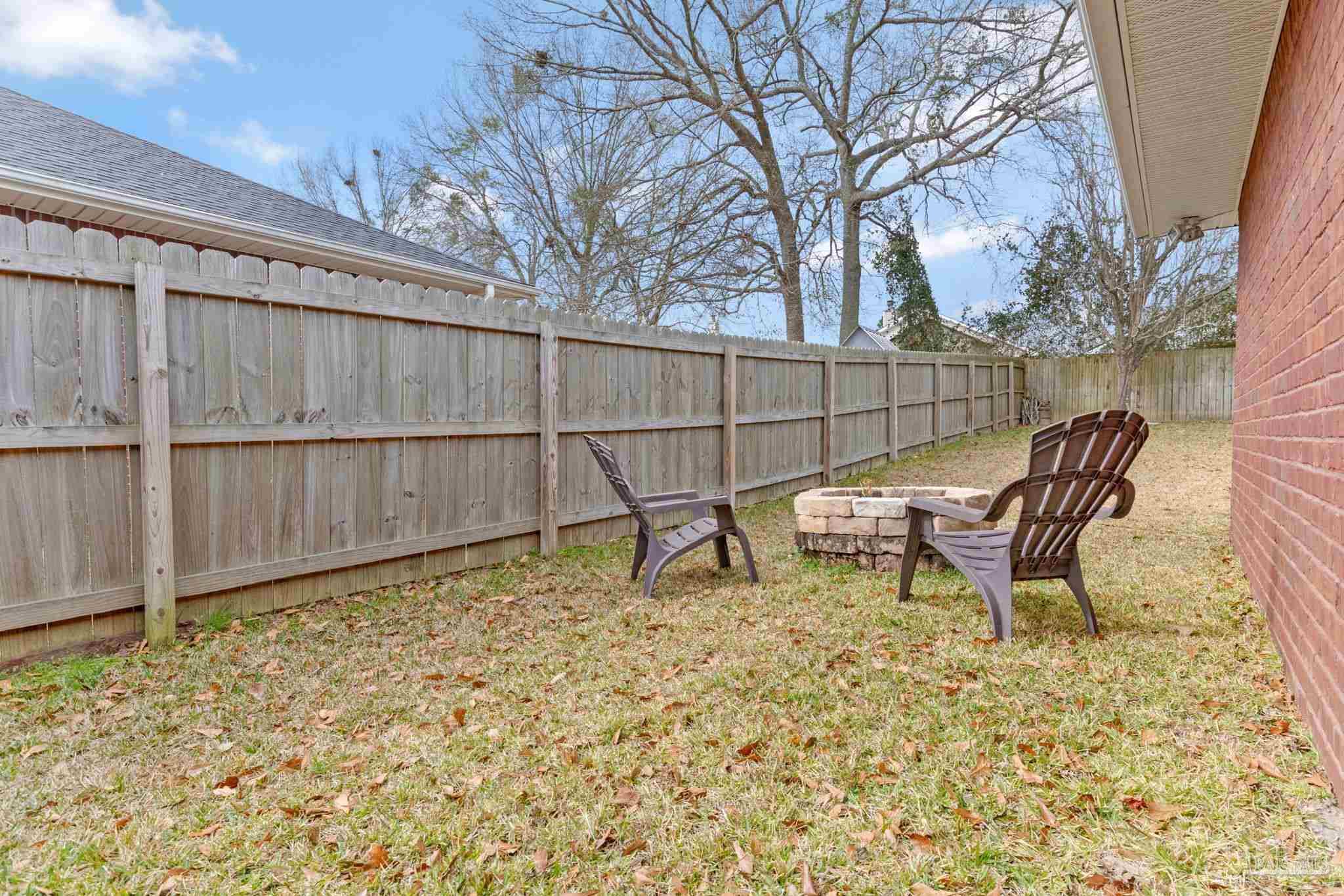 2407 Pine Forest Road Cantonment, FL 32533 - Photo 48 of 60 a view of a backyard with wooden fence and a bench