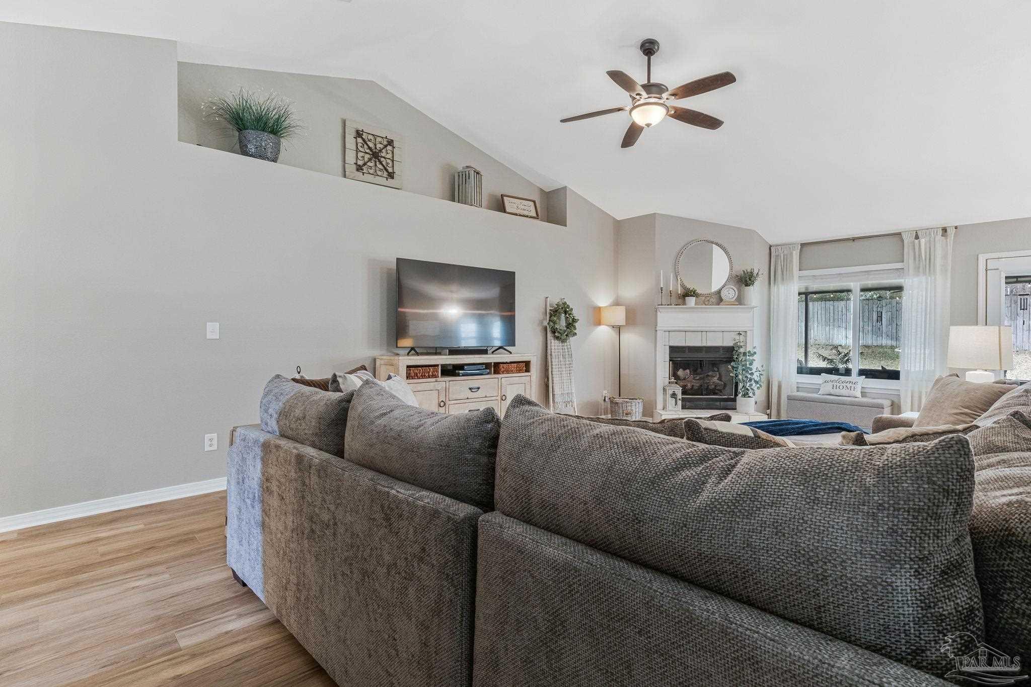 2407 Pine Forest Road Cantonment, FL 32533 - Photo 6 of 60 a living room with furniture a fireplace and a flat screen tv