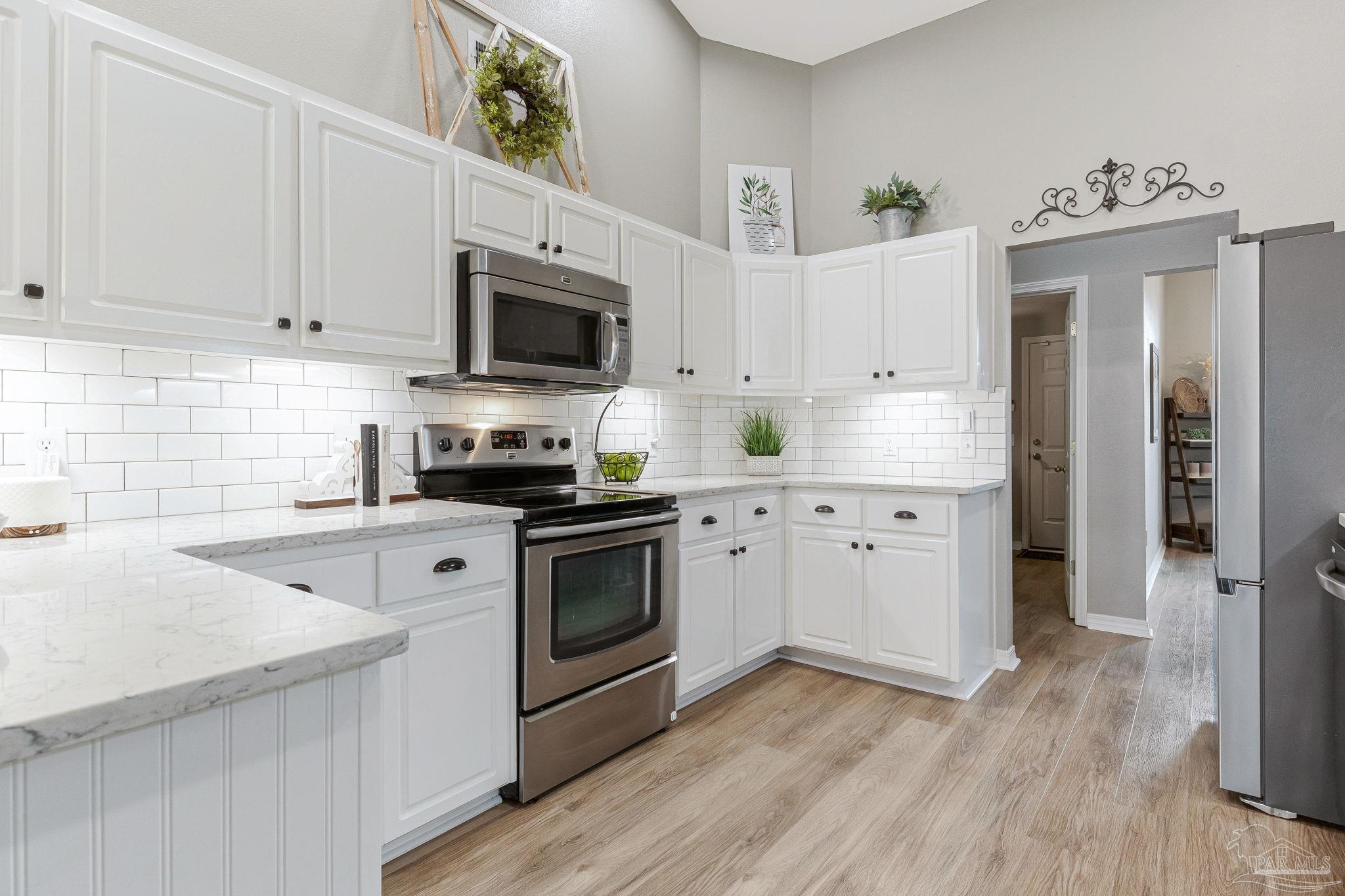 2407 Pine Forest Road Cantonment, FL 32533 - Photo 9 of 60 a kitchen with granite countertop a sink cabinets and stainless steel appliances