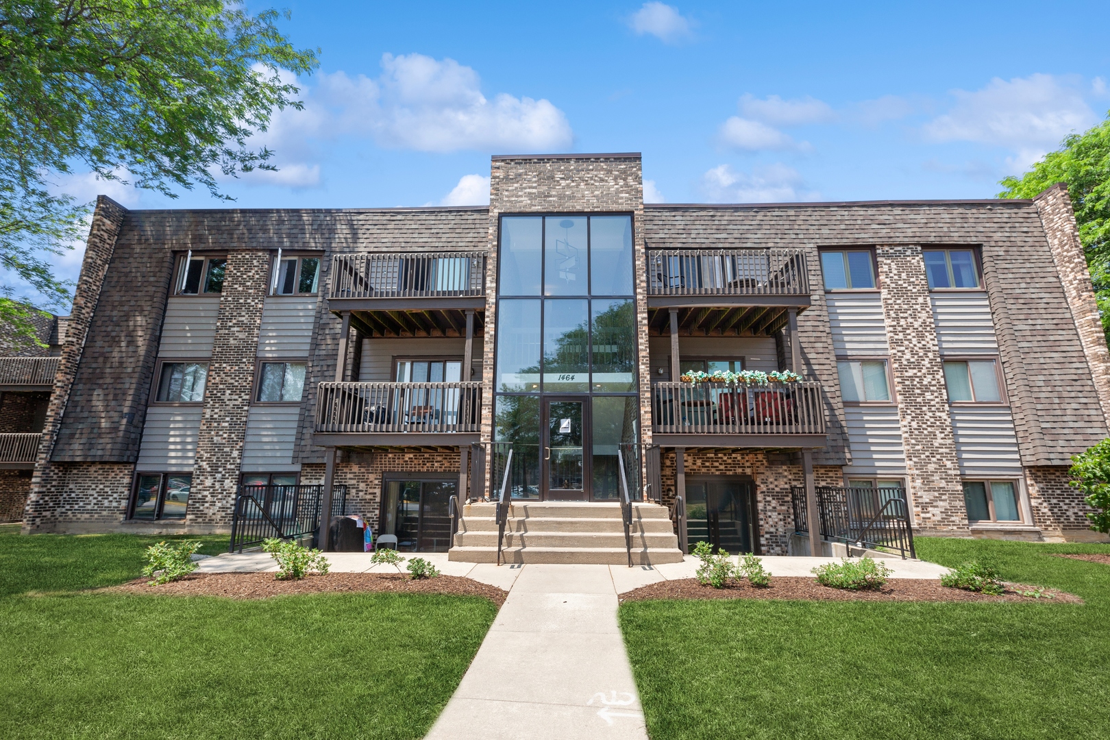 1464 Stonebridge Circle, Unit E2 Wheaton, IL 60189 - Photo 1 of 14 a view of a house with a yard and sitting area