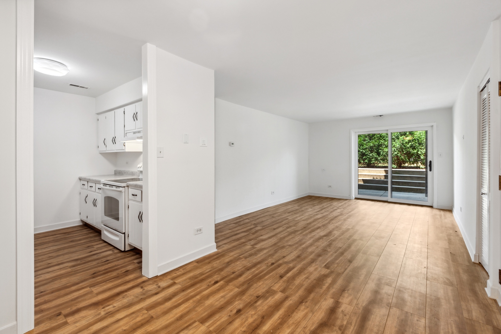 1464 Stonebridge Circle, Unit E2 Wheaton, IL 60189 - Photo 3 of 14 a view of a kitchen with wooden floor and a refrigerator