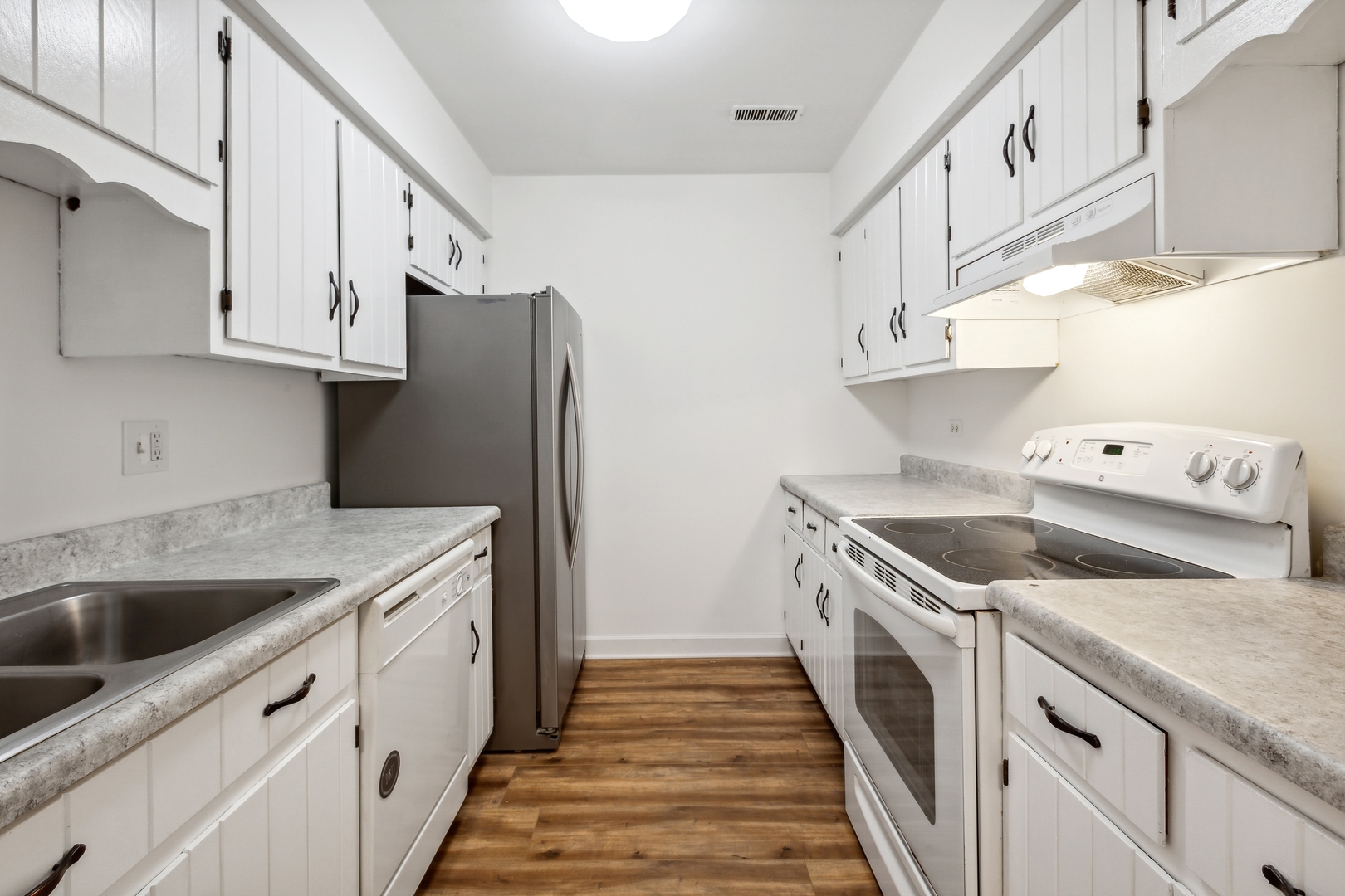 1464 Stonebridge Circle, Unit E2 Wheaton, IL 60189 - Photo 4 of 14 a kitchen with granite countertop a sink a stove and refrigerator