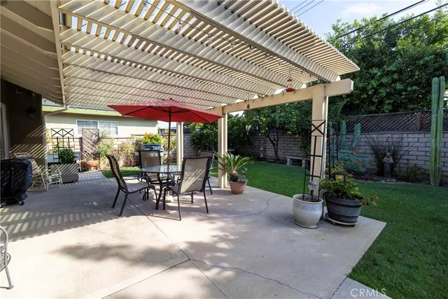 a view of a patio with a table and chairs under an umbrella