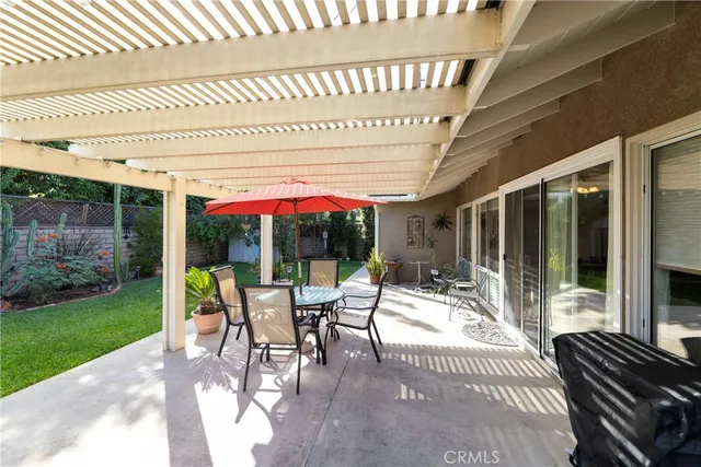 a view of a patio with a dining table and chairs under an umbrella