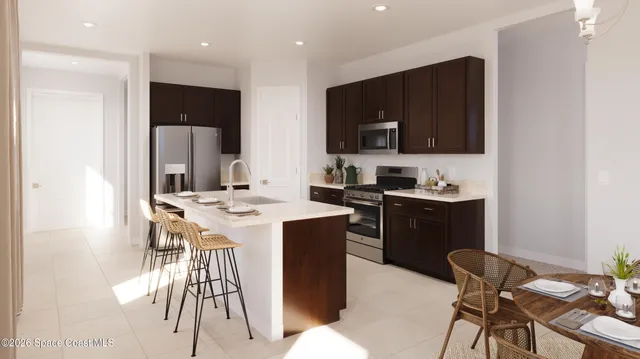 a kitchen with a sink a refrigerator and chairs