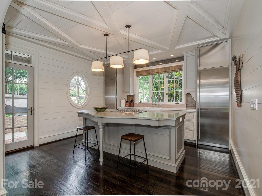 1056 Bolling Road Charlotte, NC 28207 - Photo 15 of 48 a kitchen with stainless steel appliances granite countertop a stove a refrigerator a oven a dining table and chairs with wooden floor
