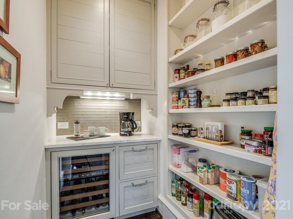 1056 Bolling Road Charlotte, NC 28207 - Photo 23 of 48 a kitchen with white cabinets and wooden floor