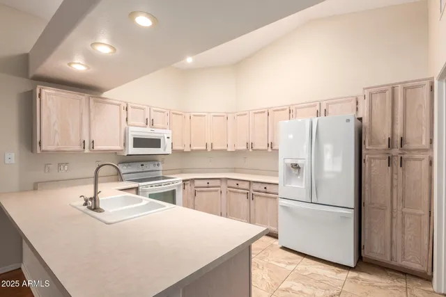 a kitchen with appliances a sink and cabinets