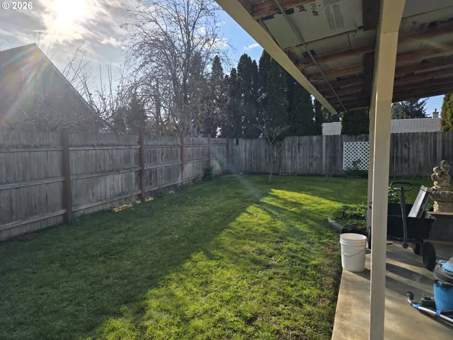 a view of a backyard with potted plants and wooden fence
