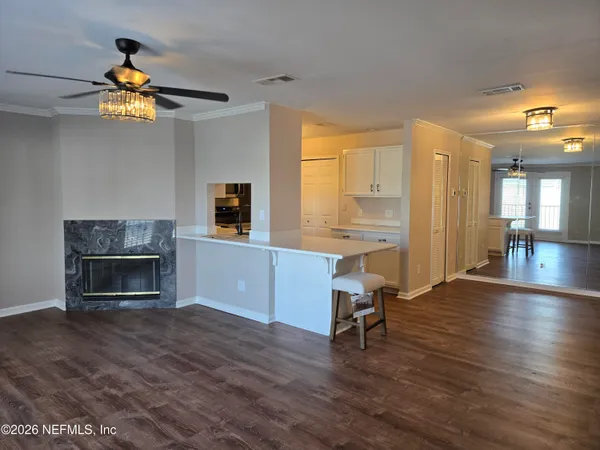 a view of a livingroom with a fireplace a window and wooden floor