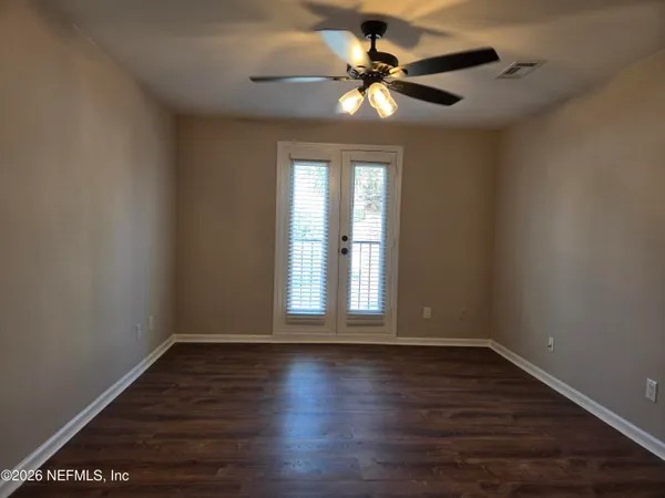 a view of wooden floor and a chandelier fan in a room