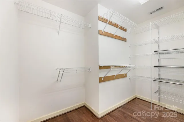 a view of walk in closet with empty racks