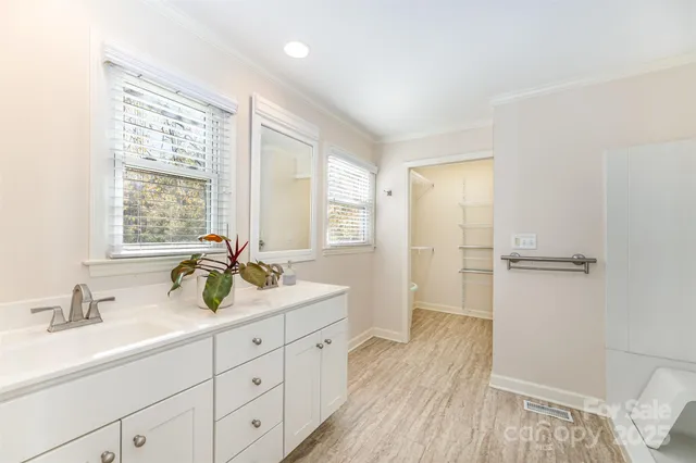 a bathroom with a double vanity sink a mirror and a bathtub
