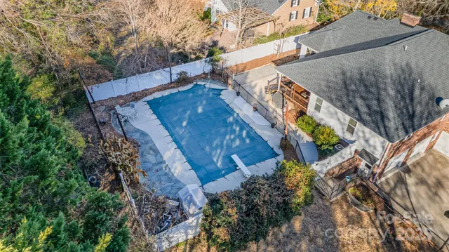 a view of a yard with plants and wooden fence