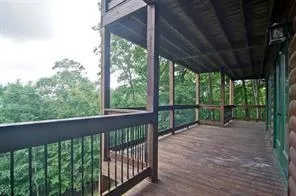 a view of a porch with a floor to ceiling window and wooden fence