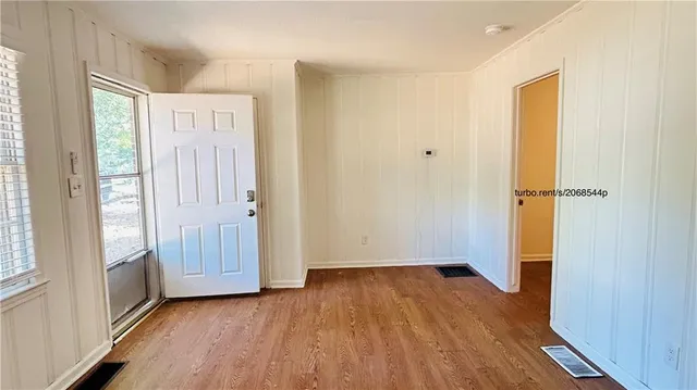 an empty room with wooden floor and a window
